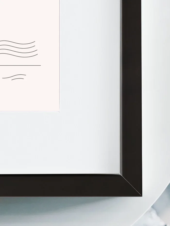 Close up of black wooden frame and white mat board around minimal wind flow study artwork