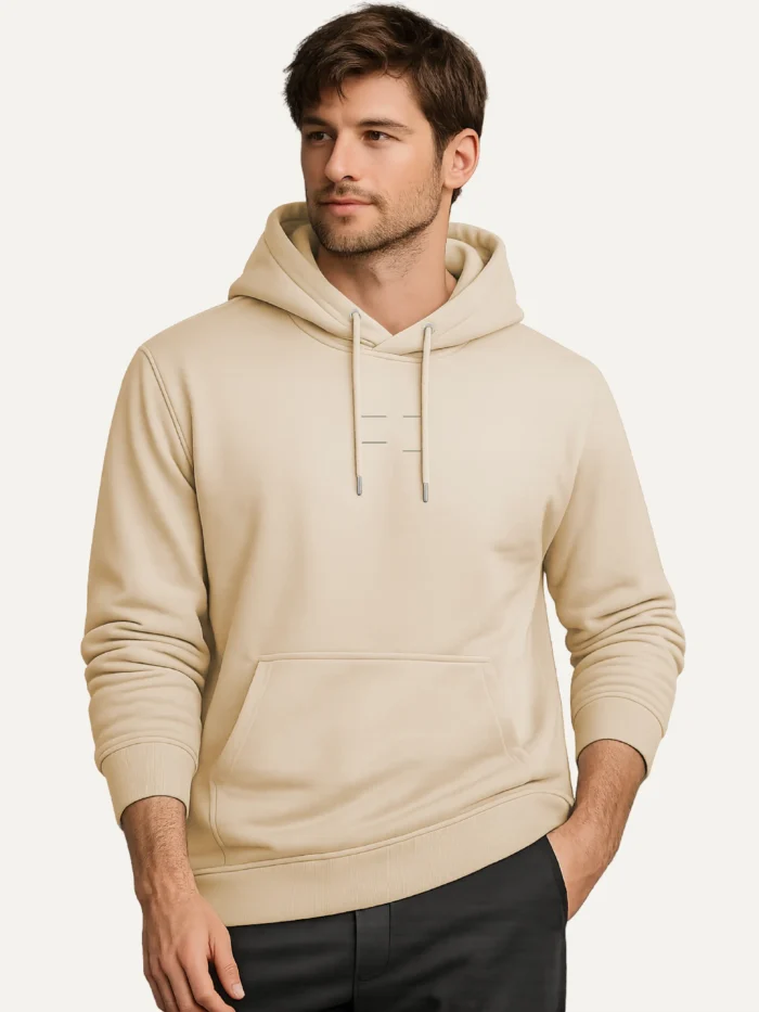 Model wearing the Seasonal Drift Organic Cotton Hoodie — Desert Dust, showing the minimal muted green centre-chest artwork and kangaroo pocket.