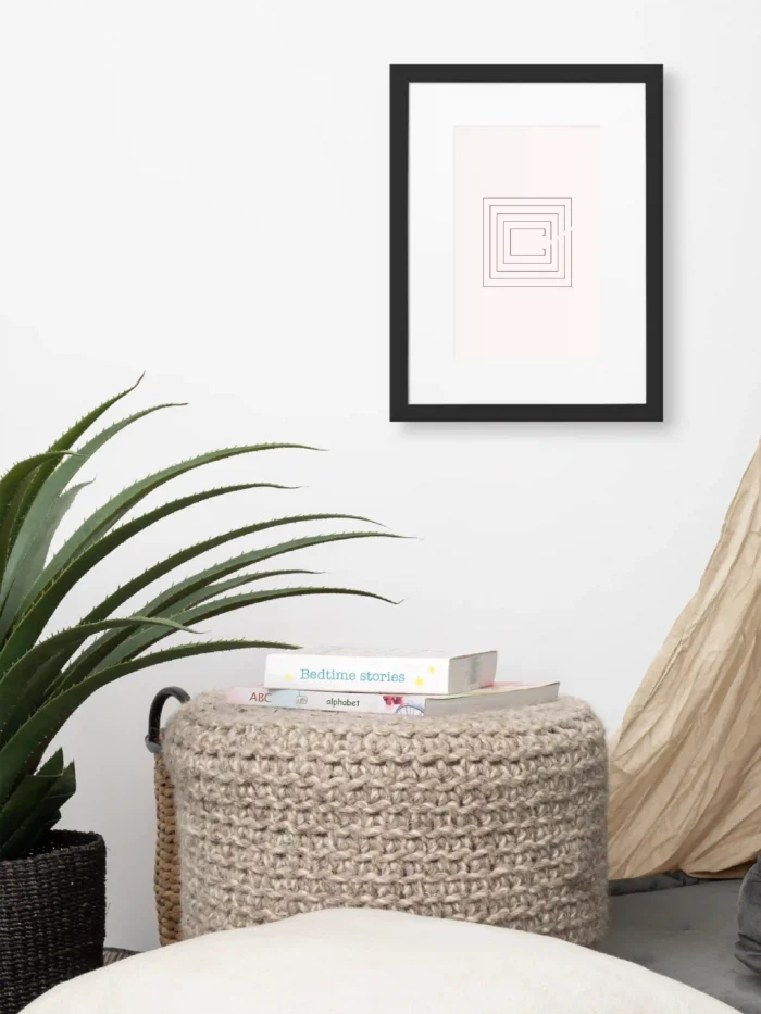 Second Look framed artwork above woven ottoman beside a large green plant